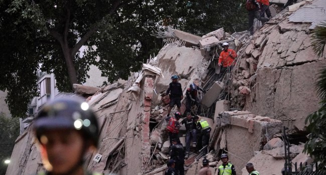 Rescue workers evacuate an injured person from a collapsed building following an earthquake in Carac (1)
