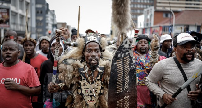 Members of the Zulu regiment known as the ‘Amabutho chant slogans as they march during a demonstrat