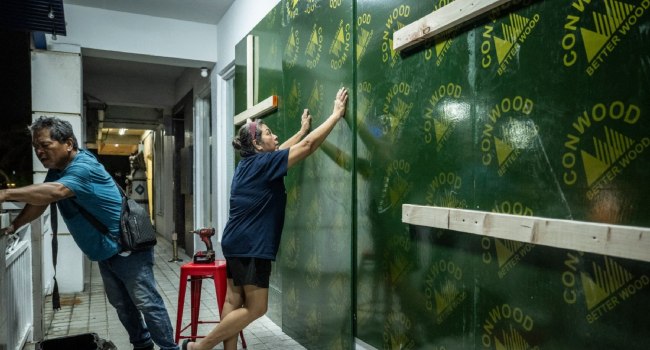 Restaurant workers board up a restaurant ahead of the arrival of the forecasted Super Typhoon Bavi in Guam on July 4, 2026